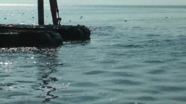 Deniz enkazı kirliliği temizleme görüntülerinde çalışan çok güzel bir kazıcı..