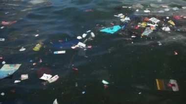 Çöp ve çöp suyun yüzeyinde yüzüyordu. Deniz yüzeyinde kirli ve plastik atık yüzen su kirliliği 