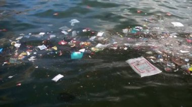 Çöp ve çöp suyun yüzeyinde yüzüyordu. Deniz yüzeyinde kirli ve plastik atık yüzen su kirliliği 