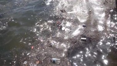 Çöp ve çöp suyun yüzeyinde yüzüyordu. Deniz yüzeyinde kirli ve plastik atık yüzen su kirliliği 