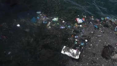 Çöp ve çöp suyun yüzeyinde yüzüyordu. Deniz yüzeyinde kirli ve plastik atık yüzen su kirliliği. 