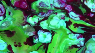 Bu stok videosu, yüzeyde yavaş çekimde yayılan renkli sıvı boya karışımının görsel efektler için organik arka plan olarak kullanılabilecek aşırı yakın çekim görüntülerini içeriyor.