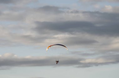 Arka planda bulutlar ve gökyüzü olan bir planör fotoğrafı..