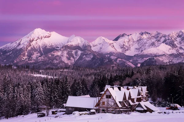 Neobyčejně barevná obloha západu slunce v horách s tradičními domy. — Stock fotografie