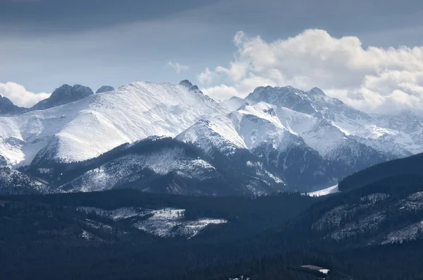 Montanhas nubladas e temperadas cobertas de neve no inverno . — Fotografia de Stock