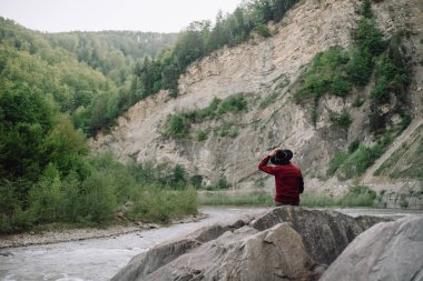  Gezgin holding şapkası ve şaşırtıcı dağlar ve kaya, yolculuk tutkusu seyahat kavramı, bakarak alanı için metin, atmosferik epik an