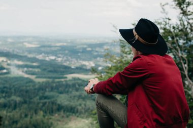 Doğa arka plan üzerine bir taş üzerinde oturan adam traveler