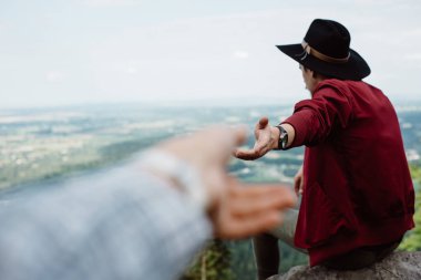 adam gezgin bir rock tutan kız yandan oturur ve doğa panorama için puan