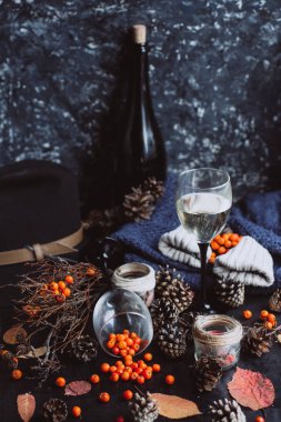  şarap gözlük, kırmızı meyveler, darbelere ve sonbahar karanlık masaya şubeleri. Sonbahar ya da kış konsepti.