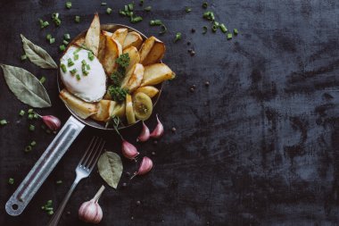  Tavada kızarmış yumurta, patates, koyu arka plan kopya alanı üzerinde taze otlar ile kahvaltı