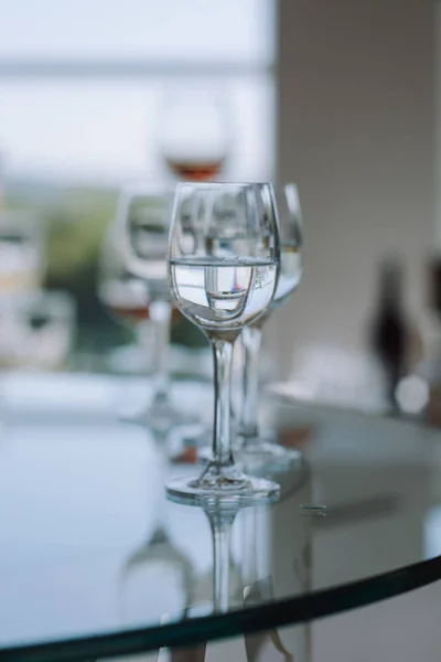 Crystal   wine glasses with alcoholic beverage on the table.