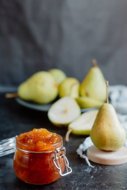 Ev yapımı armut jam arka plan üzerinde koyu renk arka plan üzerinde taze olgun armut  