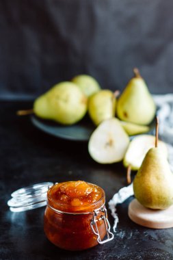 Ev yapımı armut jam arka plan üzerinde koyu renk arka plan üzerinde taze olgun armut  