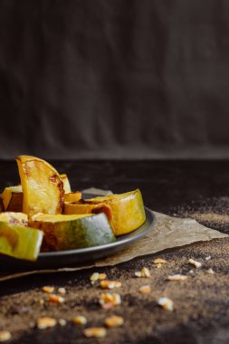 Fırında kabak koyu arka plan üzerine bir tabak içinde baharatlar ile