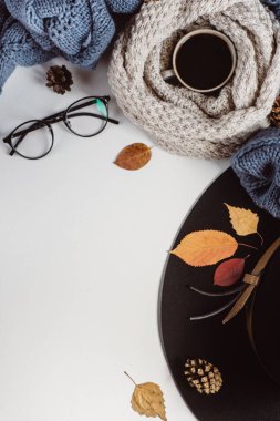 Sonbahar yaprakları ve tartan düz yatıyordu görünümünü fincan kahve, gözlük ve şapka beyaz zemin üzerine mavi kazak dokulu. Sonbahar konsepti.