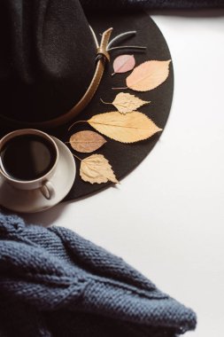 Sonbahar yaprakları ve tartan düz yatıyordu görünümünü fincan kahve, gözlük ve şapka beyaz zemin üzerine mavi kazak dokulu. Sonbahar konsepti.