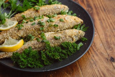 Ahşap masa üzerinde bir tabak kızarmış balık