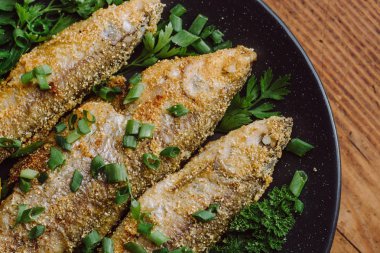 Ahşap masa üzerinde bir tabak kızarmış balık