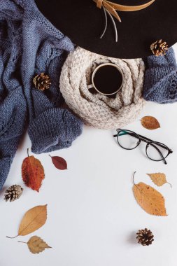 Sonbahar yaprakları ve tartan düz yatıyordu görünümünü fincan kahve, gözlük ve şapka beyaz zemin üzerine mavi kazak dokulu. Sonbahar konsepti.