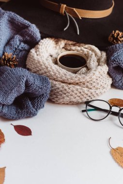 Sonbahar yaprakları ve tartan düz yatıyordu görünümünü fincan kahve, gözlük ve şapka beyaz zemin üzerine mavi kazak dokulu. Sonbahar konsepti.