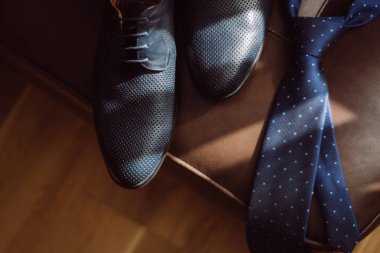 Erkek Ayakkabı ve deri koltuk üzerinde mavi bir kravat. Düğün detayları
