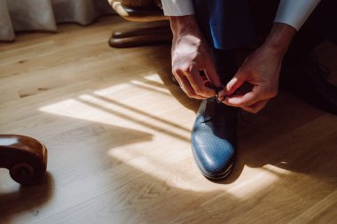 adam bir sandalyede oturuyor ve telleri Ayakkabı bağlama.