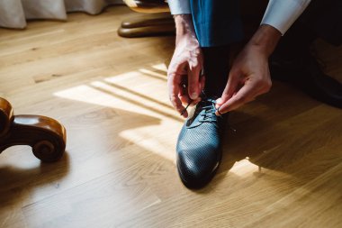 adam bir sandalyede oturuyor ve telleri Ayakkabı bağlama.