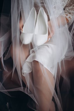gelin beyaz ayakkabı onun elinde tutar. Sabah gelin