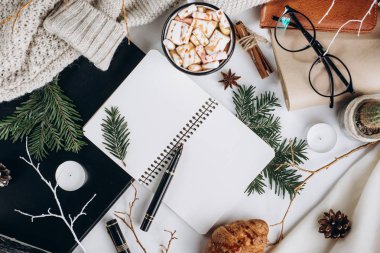 Kış düz yatıyordu. Sıcak çikolata veya kakao ile hatmi, kurabiye, defter ve tartan dokulu süveter ile beyaz arka plan üzerinde.