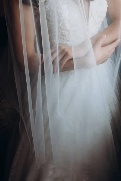 Gentle hands of the bride on the dress. Morning of the bride.