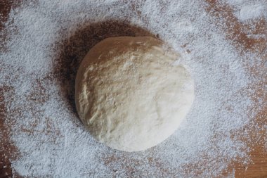 Topu çiğ hamur rustik ahşap sayaçta un serpilir