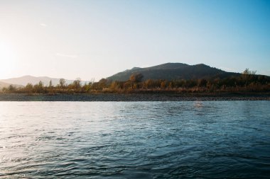 Gün batımını dağlarda nehrin üzerinde