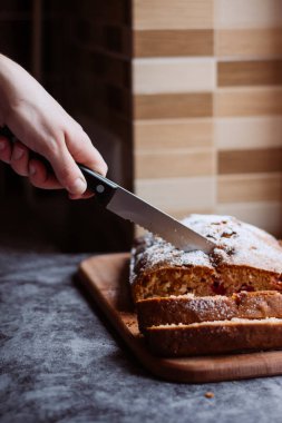 Ev yapımı geleneksel tatlı kiraz pasta ile pudra şekeri serpilir. Bir kadın bir pasta keser