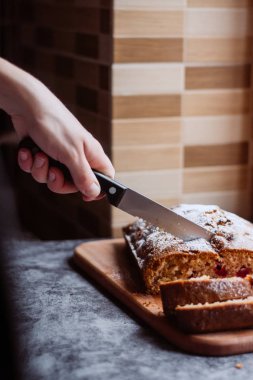 Ev yapımı geleneksel tatlı kiraz pasta ile pudra şekeri serpilir. Bir kadın bir pasta keser