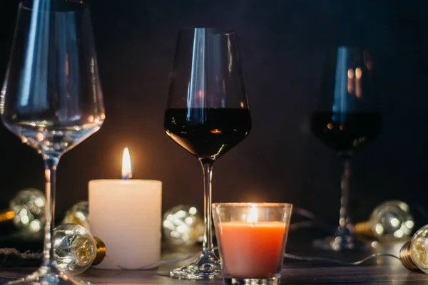 Samenstelling Van Vakantie Gemaakt Van Glas Rode Wijn Kaarsen Slingers — Stockfoto