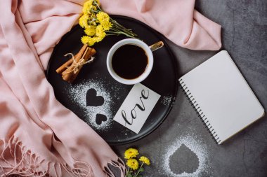 Sevgililer günü. Fincan kahve, defter, eşarp, çiçek, tarçın ve kalp düz yatıyordu tarzda yukarıdan gri masada.