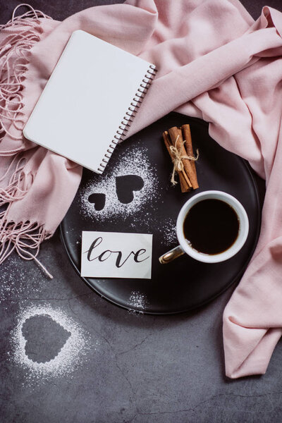 День Святого Валентина. Чашка кофе, блокнот, шарф, корица и сердце на сером столе сверху в плоском стиле
.