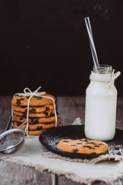 Cam taze süt ve ev yapımı çikolata ile çerezleri ahşap bir masaya cips.. 