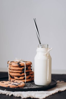 Cam taze süt ve ev yapımı çikolata ile tanımlama karanlık bir tablo üzerinde fiş. 