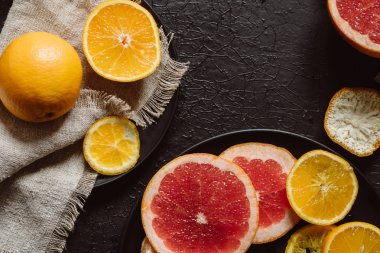 Lezzetli çeşitli türleri Taze narenciye meyve tabakları koyu arka plan üzerinde