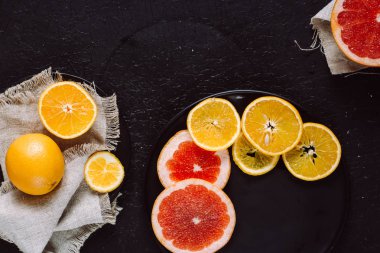 Lezzetli çeşitli türleri Taze narenciye meyve tabakları koyu arka plan üzerinde