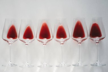 Bardak kırmızı şarap, düz beyaz arka plan üzerinde yatıyordu, kopya alanı. Şarap tadım kavramı