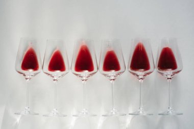 Bardak kırmızı şarap, düz beyaz arka plan üzerinde yatıyordu, kopya alanı. Şarap tadım kavramı