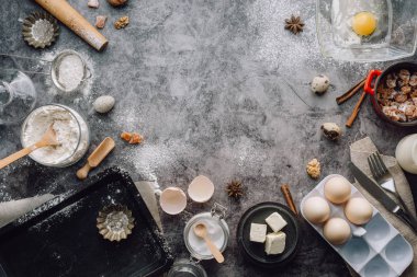 Sağlıklı Pişirme malzemeleri. Kaşık un, yemekler, yumurta, tereyağı tuz ve gri arka plan üzerinde oklava ile. Fırın arka plan çerçeve. Üstten görünüm, kopya alanı.