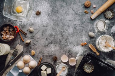 Sağlıklı Pişirme malzemeleri. Kaşık un, yemekler, yumurta, tereyağı tuz ve gri arka plan üzerinde oklava ile. Fırın arka plan çerçeve. Üstten görünüm, kopya alanı.