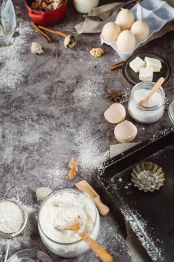 Sağlıklı Pişirme malzemeleri. Kaşık un, yemekler, yumurta, tereyağı tuz ve gri arka plan üzerinde oklava ile. Fırın arka plan çerçeve. Üstten görünüm, kopya alanı.