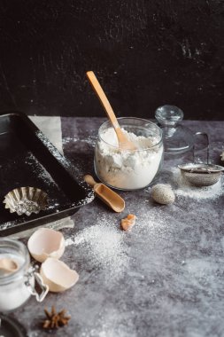 Sağlıklı Pişirme malzemeleri. Kaşık un, yemekler, yumurta, tereyağı tuz ve gri arka plan üzerinde oklava ile. Fırın arka plan çerçeve. Üstten görünüm, kopya alanı.