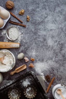 Sağlıklı Pişirme malzemeleri. Kaşık un, yemekler, yumurta, tereyağı tuz ve gri arka plan üzerinde oklava ile. Fırın arka plan çerçeve. Üstten görünüm, kopya alanı.