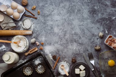 Sağlıklı Pişirme malzemeleri. Kaşık un, yemekler, yumurta, tereyağı tuz ve gri arka plan üzerinde oklava ile. Fırın arka plan çerçeve. Üstten görünüm, kopya alanı.