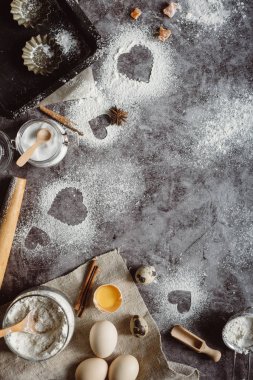 Sağlıklı Pişirme malzemeleri. Un, oklava, yumurta ve kalp şekli mutfak gri mutfak masasının üzerinde arka plan. Üstten görünüm Sevgililer günü yemek pişirmek için. Kopya alanı.